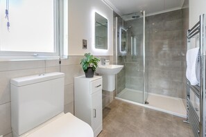 A modern bathroom with a toilet, sink, and shower. - 3 Bed in Broadwoodwidger (oc-s31783) (Broadwoodwidger)