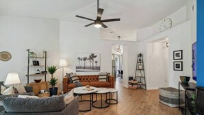 Una sala de estar moderna con sofá, mesa de centro y ventilador de techo.