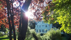 A large building with multiple windows and a well-maintained lawn in the foreground. - Château Picol (Lencloitre)