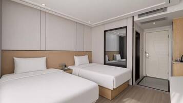 A hotel room with two beds, a large mirror, and a door leading to the outside.