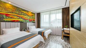 A hotel room with two beds, a desk, a TV, and a large window with curtains.