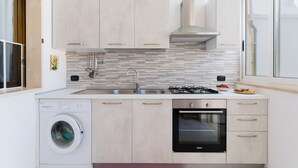 Una cocina moderna con lavadora, horno y salpicadero de azulejos.