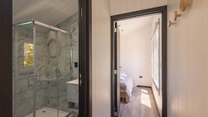A modern bathroom with a glass shower enclosure and a walk-in shower. - Tiny House (San Martin de los Andes)
