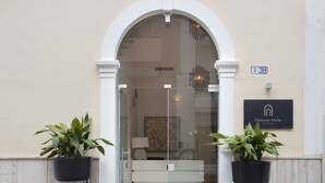 A hotel entrance with a large arched doorway, a sign indicating room number 38, and a plaque for Palazzo Perla Rooms and Suite. - Palazzo Perla - Junior Suite con Balcone (Gallipoli)