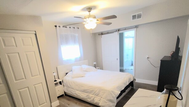 A bedroom with a bed, a desk, a ceiling fan, and a window with curtains. - Charming 1 bed suite with AC and WiFi in Lakeland (Lakeland)