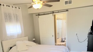 A bedroom with a bed, a ceiling fan, a desk, and a chair. - Charming 1 bed suite with AC and WiFi in Lakeland (Lakeland)