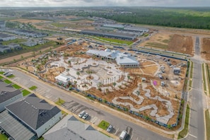 An aerial view of a residential area with houses, roads, and a large building under construction.