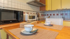 Una cocina equipada con microondas, tostadora y espacio para preparar café.