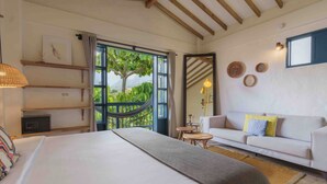 Una habitación de hotel con una cama grande, un sofá, una mesita y una hamaca.