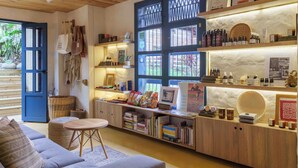 Una habitación acogedora con techo de madera, una puerta azul, una estantería y una pequeña mesa.