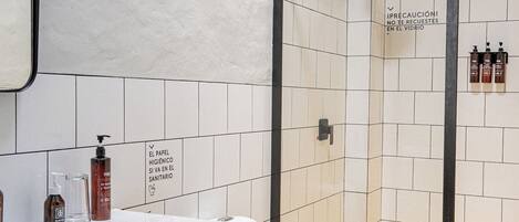 A bathroom with a white sink, a toilet, and a shower area.