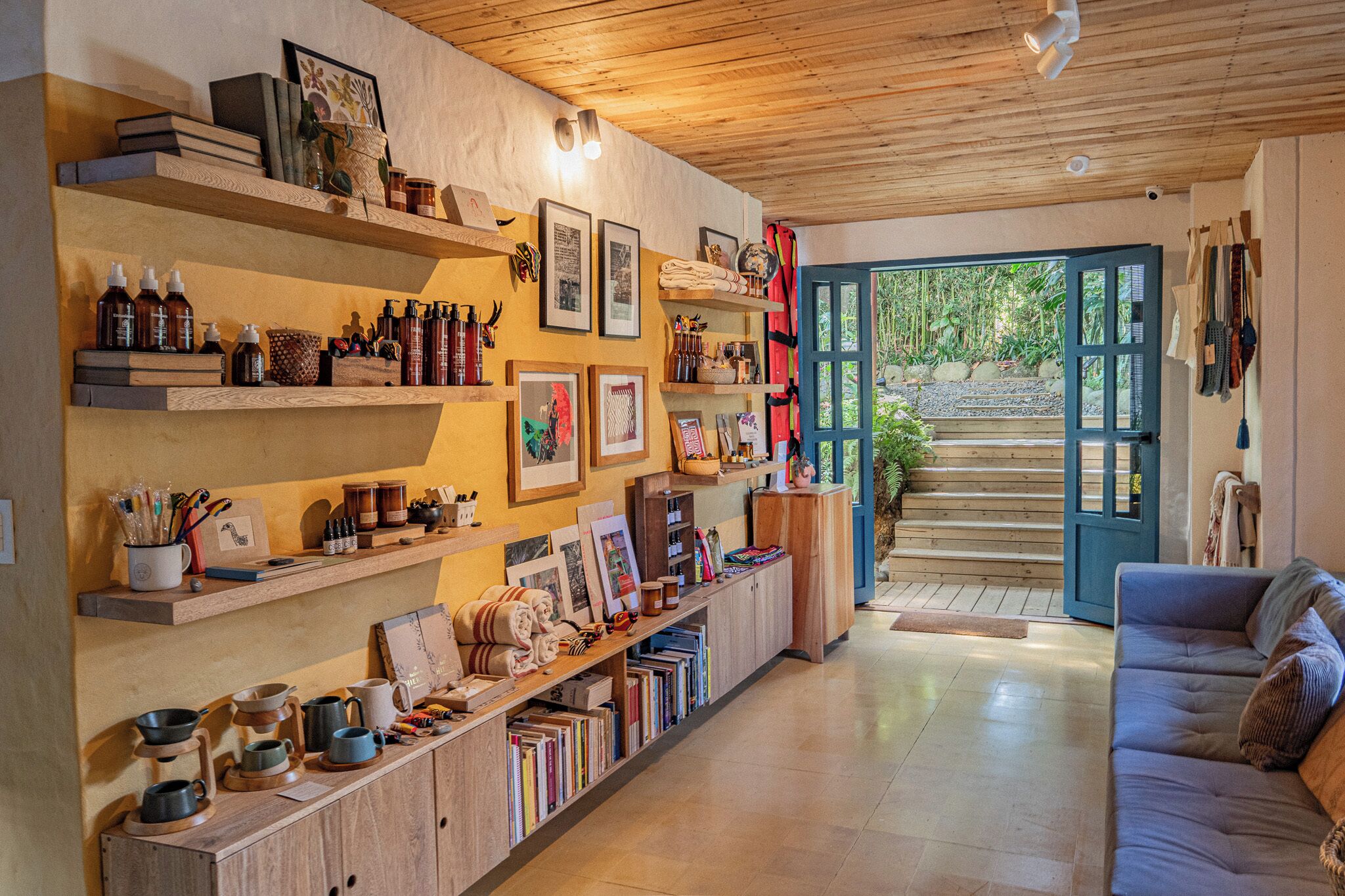 A cozy interior with wooden shelves, a sofa, and a view through a door.