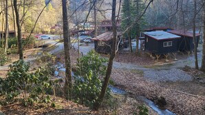 A cabin with a red roof, surrounded by trees and a gravel path. - Black Bear Resort (Hampton)