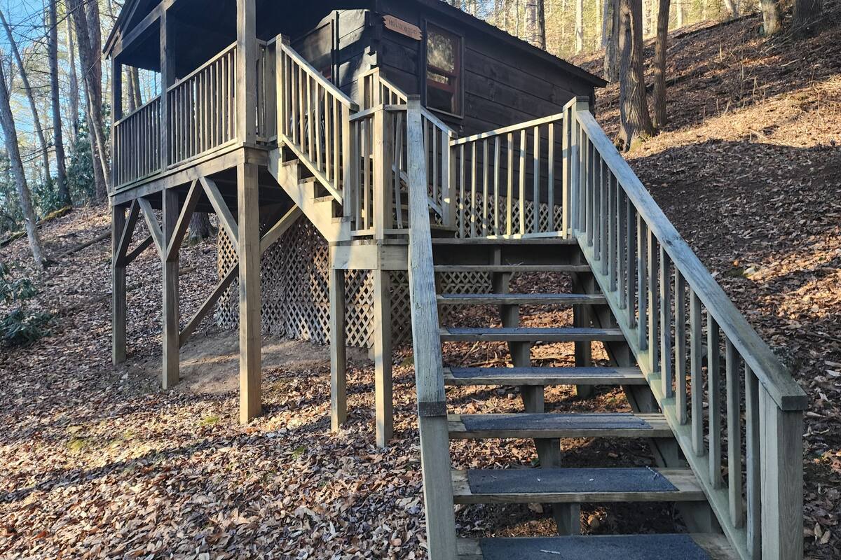 A wooden cabin with a staircase leading to a deck.