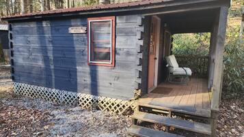 Une petite cabane en bois avec une véranda, une enseigne sur laquelle on peut lire « MOUNTAIN MAMA », et une chaise à l’extérieur.