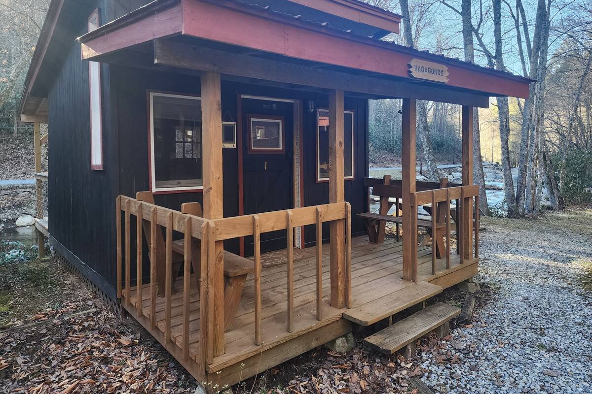 A cabin with a wooden deck, a covered porch, and a sign reading "VAGABONDS".