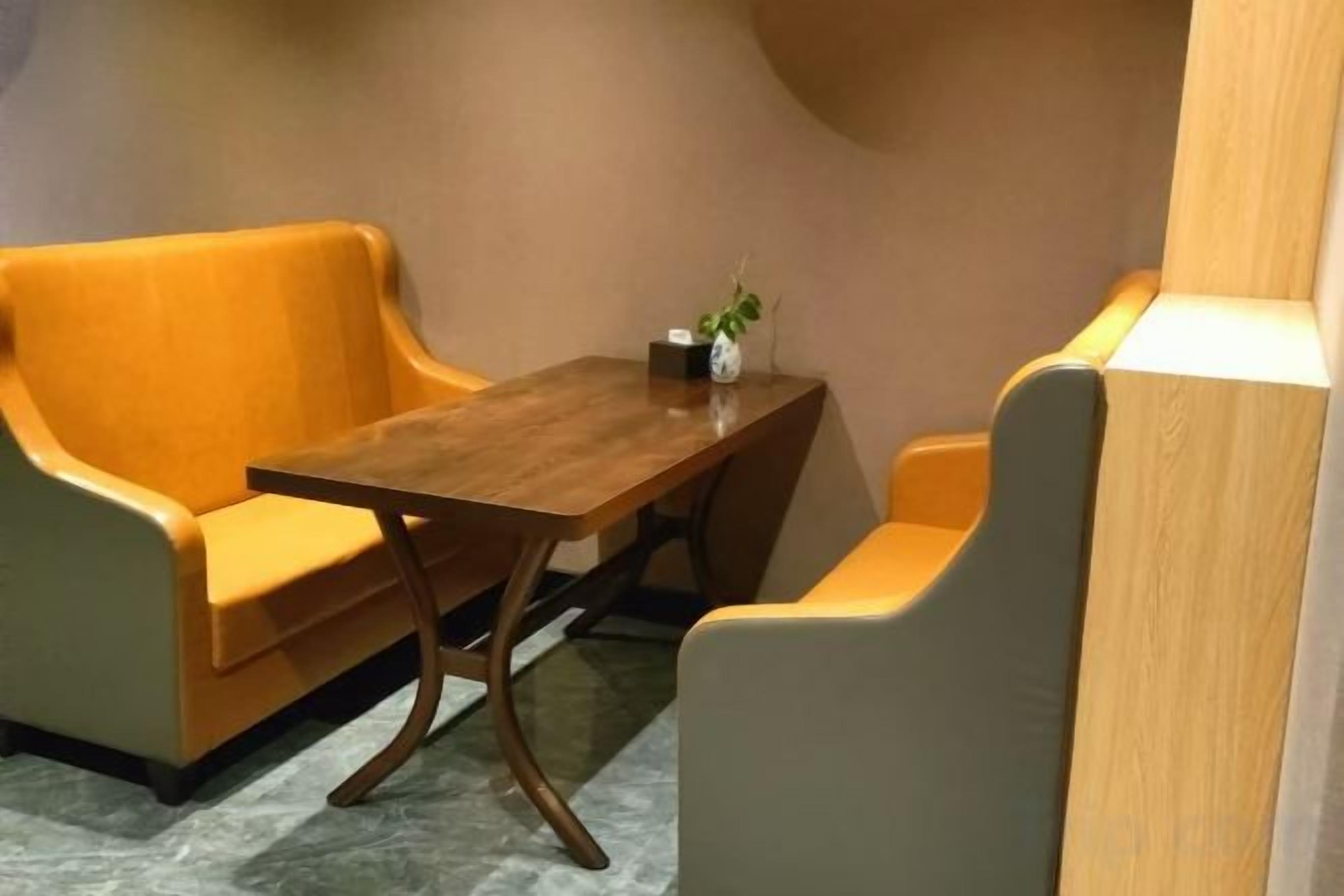 Una habitación con una mesa de madera y dos sofás.