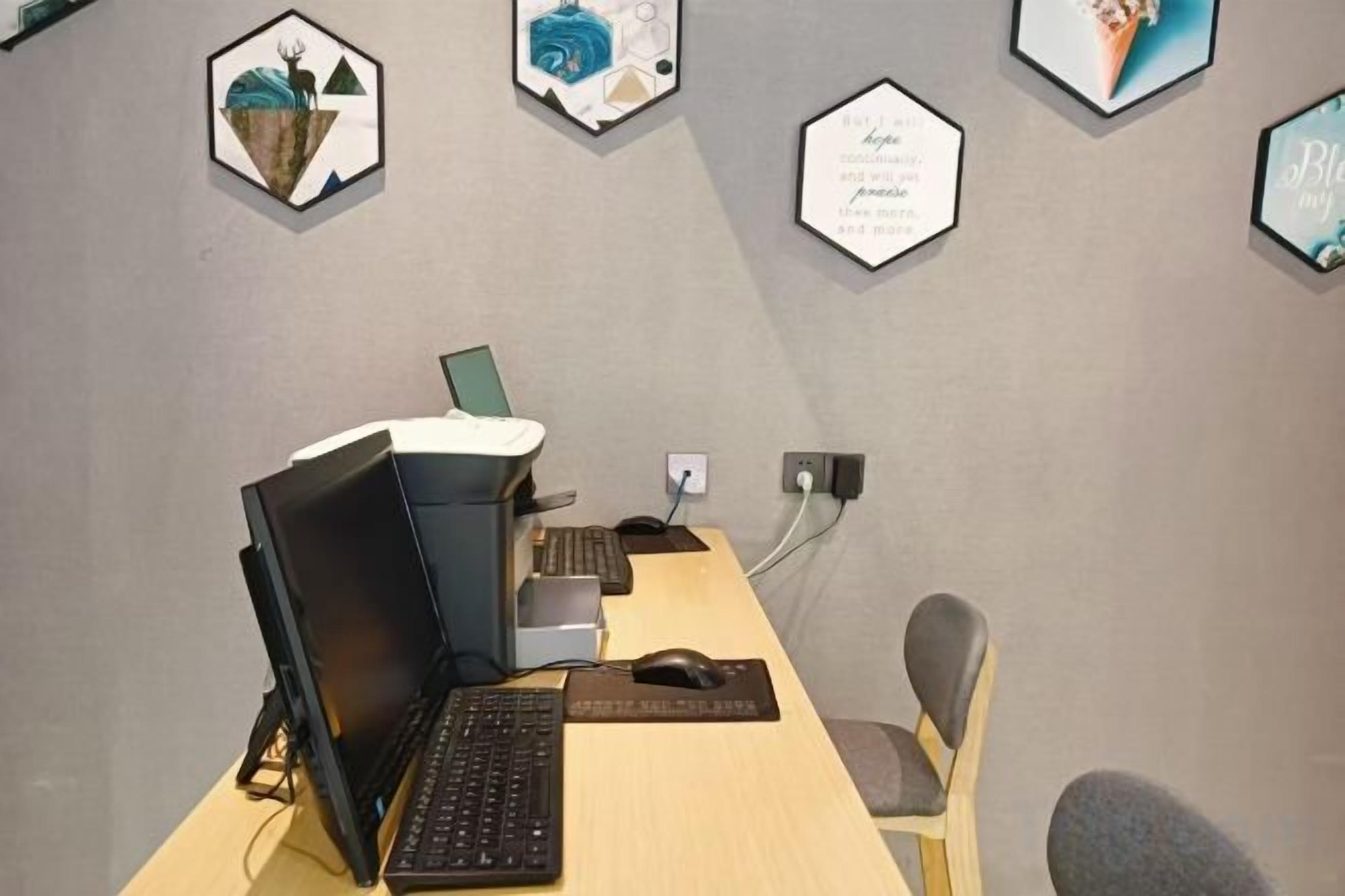 A workspace with a desk, computer, keyboard, mouse, and a chair.