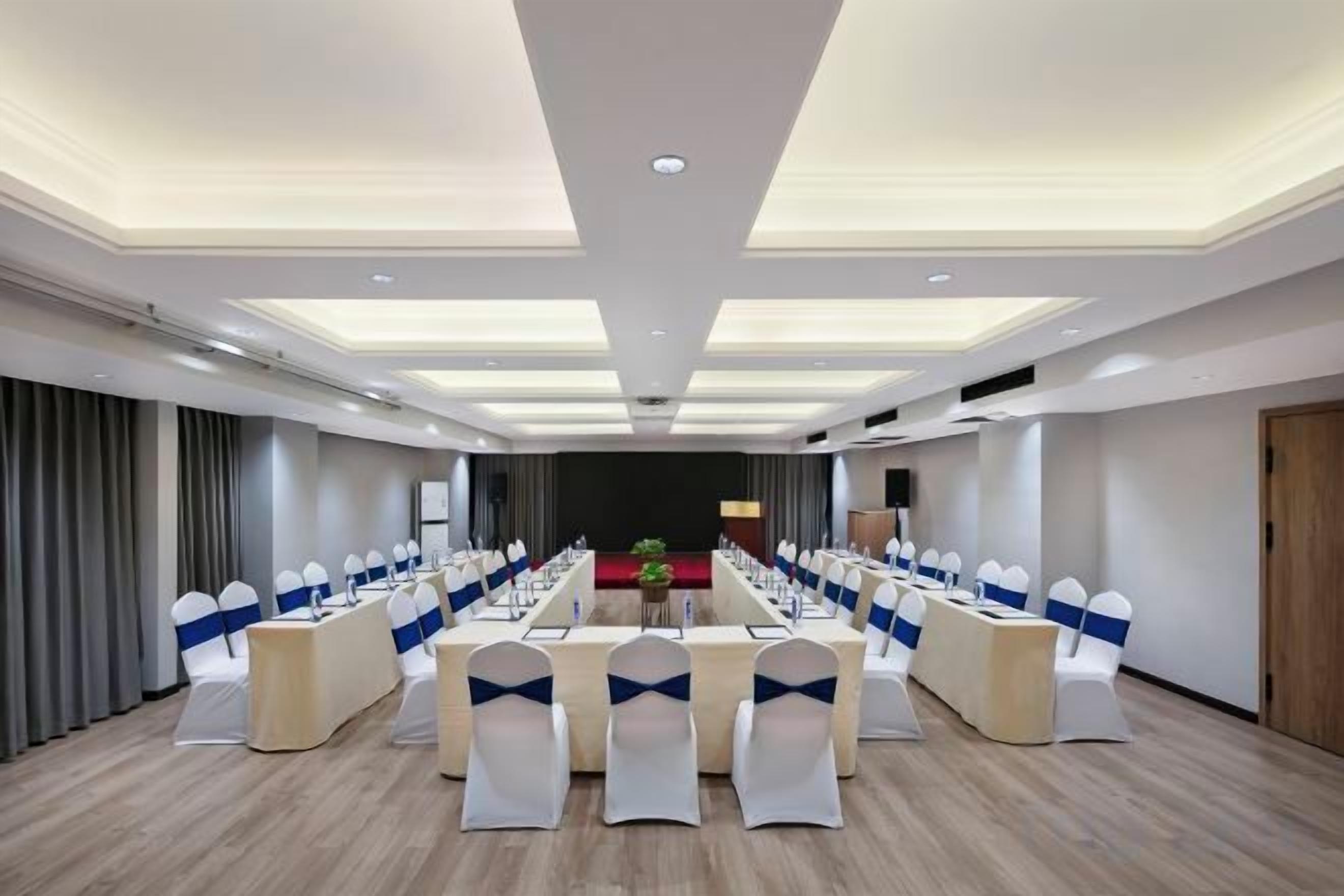 A conference room with a long table, chairs, and a podium.