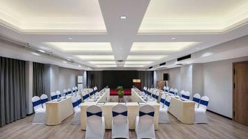 A conference room with a long table, chairs, and a podium.