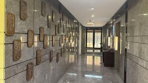 A hallway with a polished marble floor and walls adorned with plaques. - Zhengzhou Aimu International Hotel (Zhengzhou)