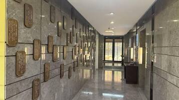 Un pasillo con piso de mármol pulido y paredes decoradas con placas.