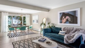 Una sala de estar moderna con un sofá azul, una mesa de centro y un comedor con sillas color turquesa.