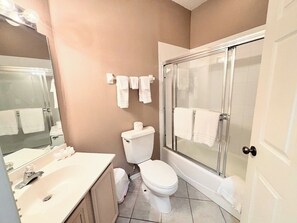 A bathroom with a toilet, sink, and shower.