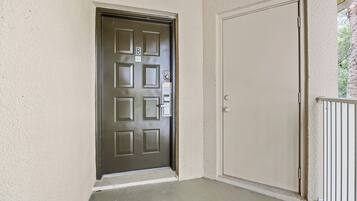A door with a keypad lock, a plain door next to it, and a concrete floor.