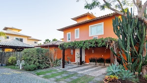 A house with a tiled roof, a garden with a cactus, and a paved driveway. - Bz70 Casa Piscina 650m da Rua das Pedras (Buzios)