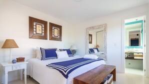 A bedroom with a bed, bedside tables, a bench, and a mirror. - Bz70 Casa Piscina 650m da Rua das Pedras (Buzios)