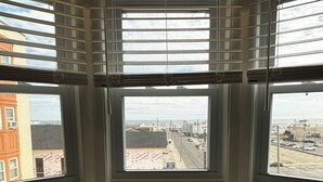 A corner window with blinds, a table, and two chairs.