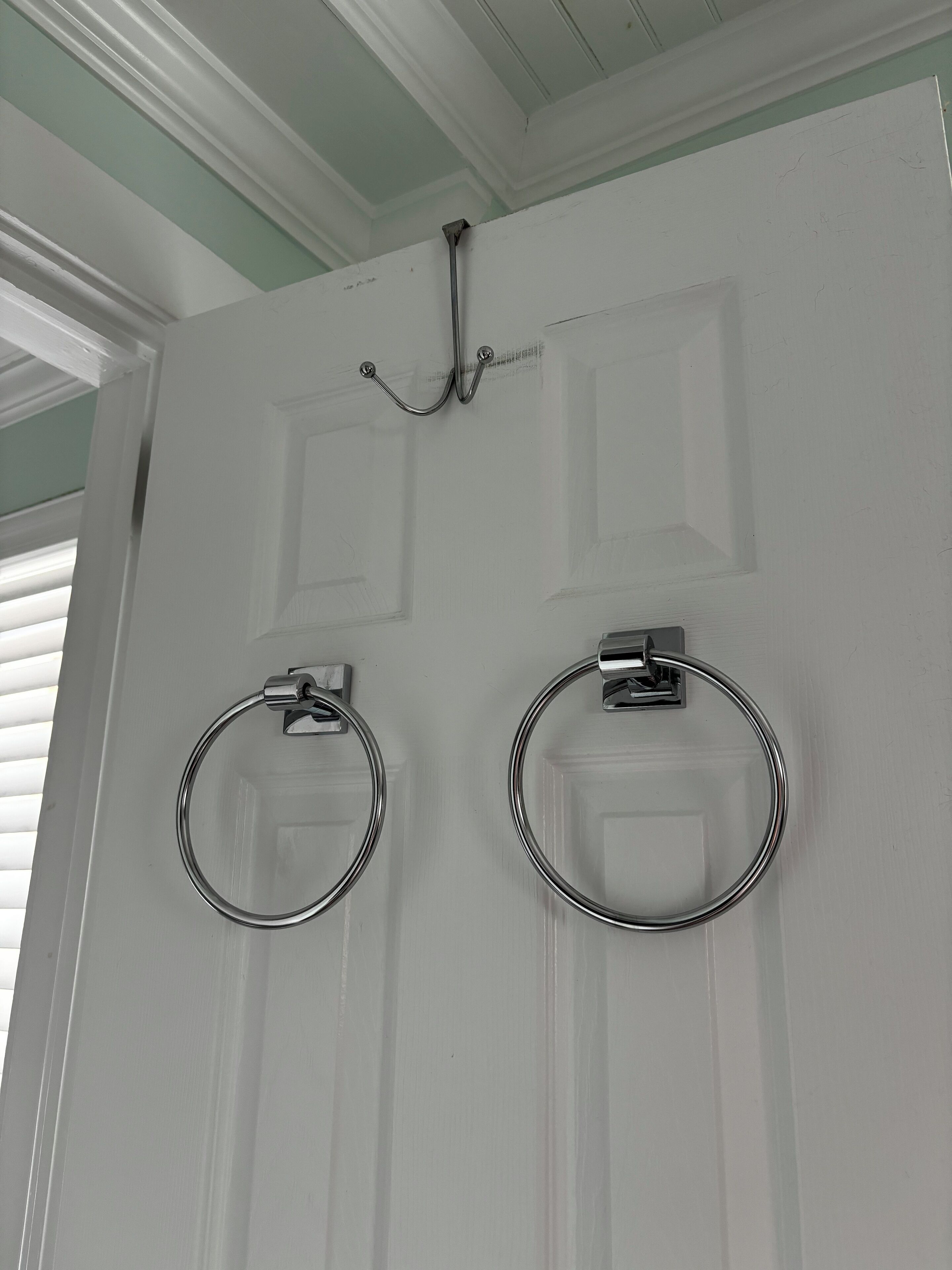 Une porte blanche ornée de deux porte-serviettes.
