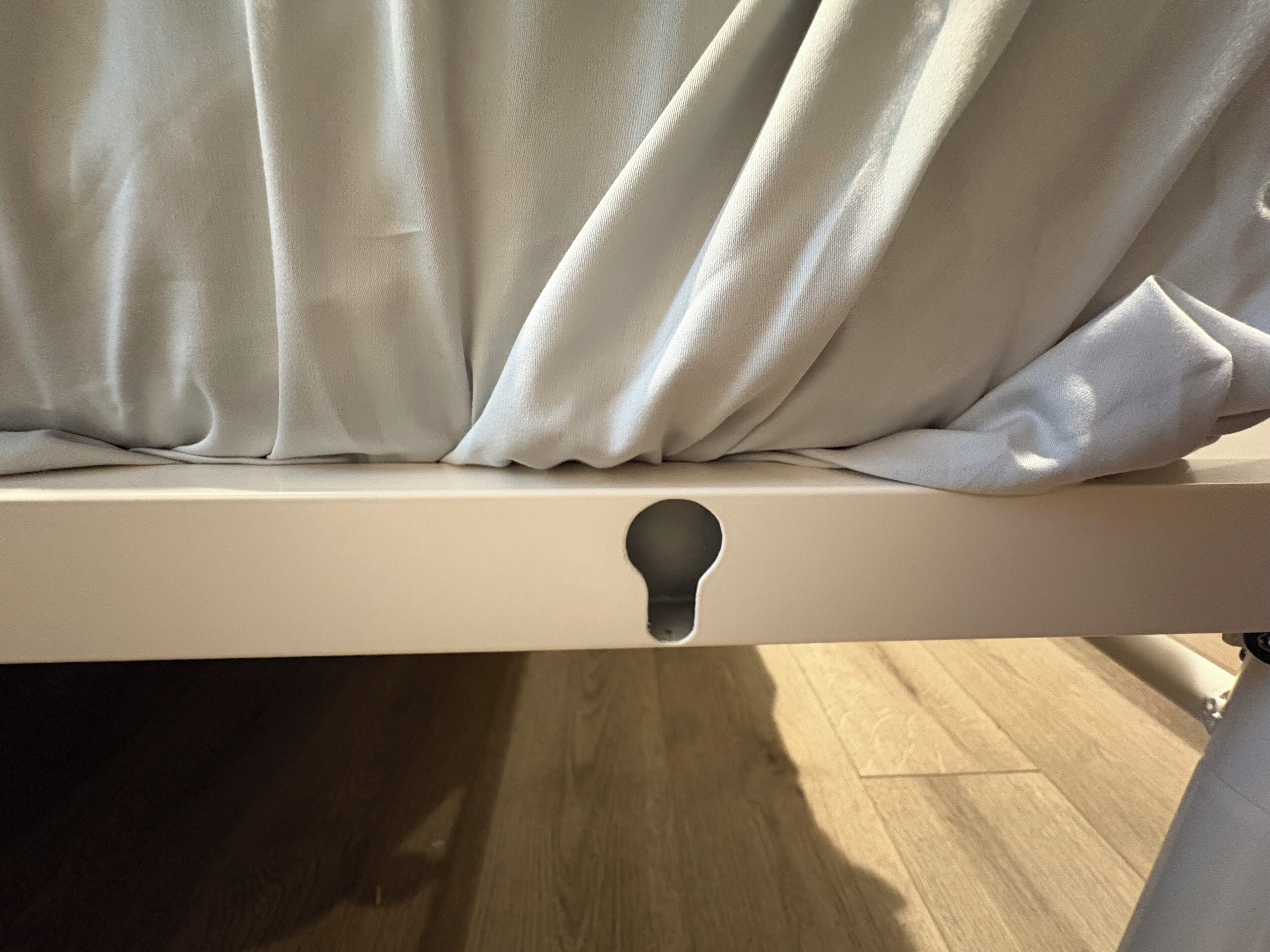 Ein Bett mit weißem Kopfteil und Schlüsselloch-Ausschnitt.