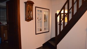 Una escalera con barandas de madera y una puerta con paneles de vidrio.