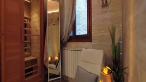 A cozy room with a sauna, a comfortable chair, a radiator, and a window with curtains. - SUITE HAVEN IN VENICE WITH PRIVATE SPA (Venezia)