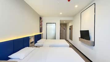 Quarto de hotel com duas camas, televisão na parede e uma pequena mesa.
