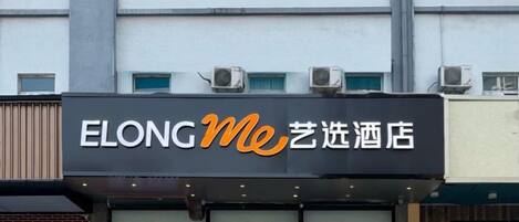 Un letrero de hotel con el nombre 'ELONG Me' y caracteres chinos.