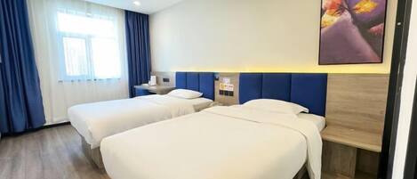 A hotel room with two beds, a large window with curtains, a wall-mounted artwork, and a wooden headboard.