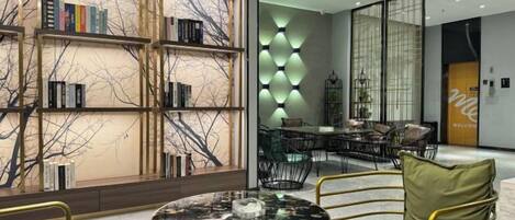 Un interno moderno con un tavolo rotondo, sedie, una libreria e una zona pranzo.
