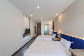 Une chambre d’hôtel avec un grand lit, des tables de chevet, une télévision et un miroir au mur.