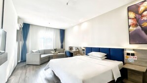 A modern hotel room with a large bed, a sofa, a desk, and a TV. - Elong ME Hotel (Shijiazhuang Railway Station Xinshizhong Road) (Shijiazhuang)
