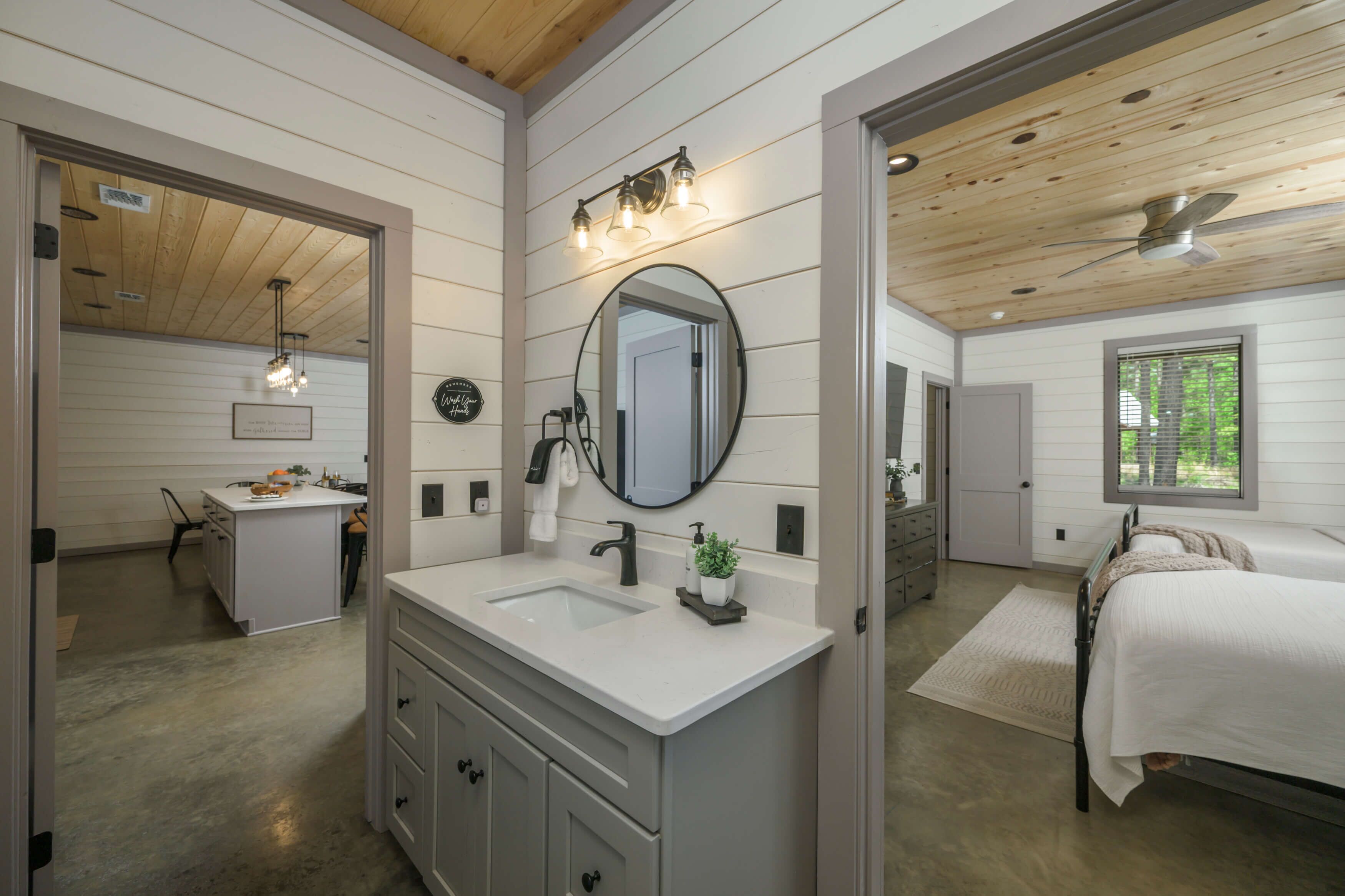 Une salle de bain avec un meuble-lavabo à deux vasques, un grand miroir et un ventilateur de plafond.