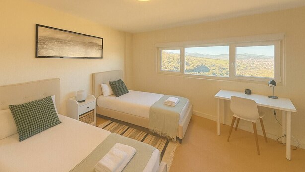 A hotel room with two beds, a desk, and a window with a view. - Vistas increíbles en Laredo (Laredo)