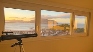 A telescope on a tripod in front of a window with a cityscape view. - Vistas increíbles en Laredo (Laredo)