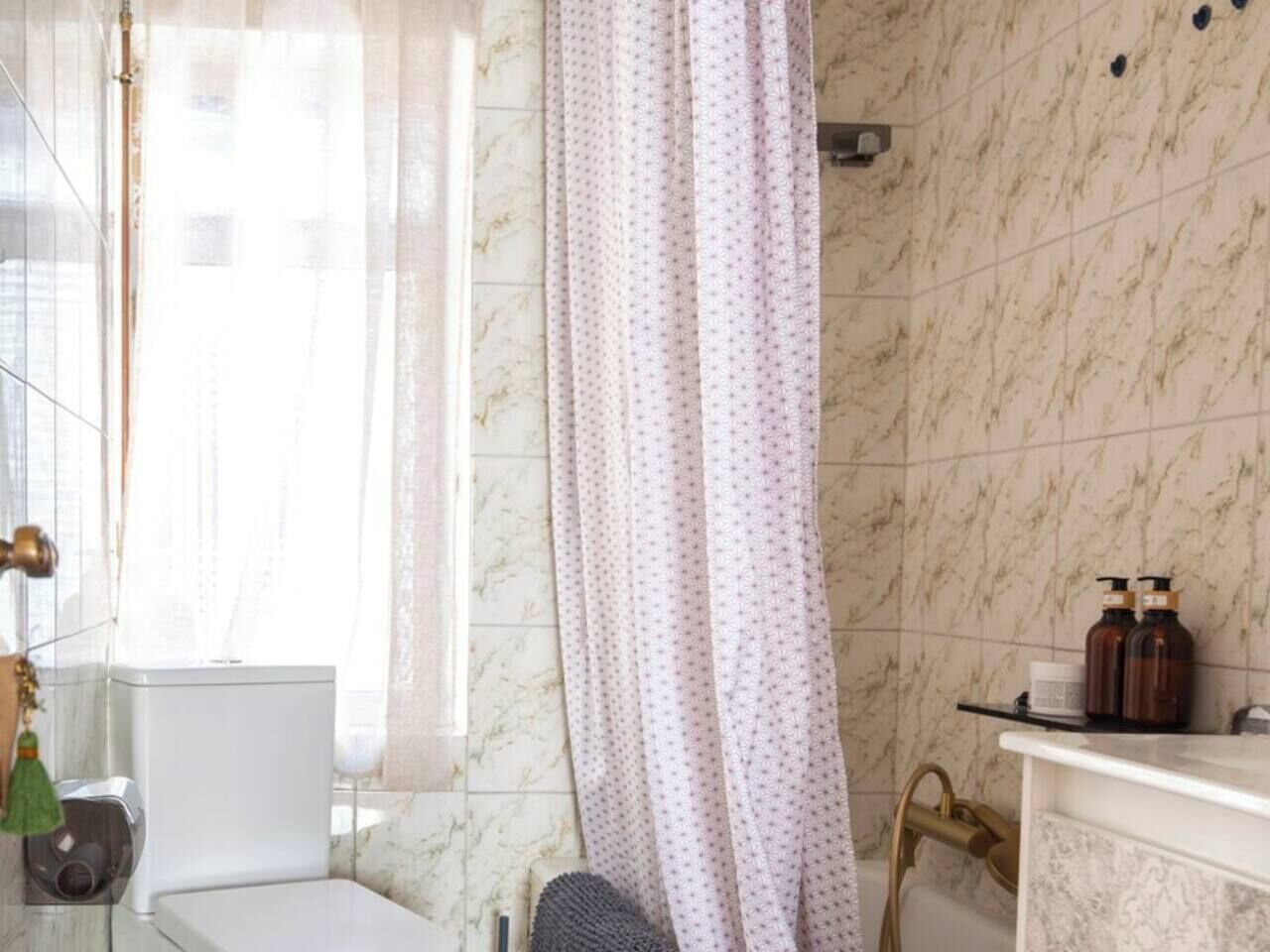 Une salle de bain avec des toilettes, un lavabo et un rideau de douche.