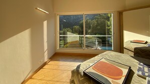A bedroom with a large window, a bed, and a nightstand. - Amazing villa 10 min to Monaco (Roquebrune-Cap-Martin)