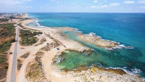 A coastal road with a beach and rocky shoreline. - Mamad Achziv Seaside Stylish Stay (Nahariya)