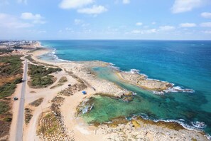 Una strada costiera con spiaggia e costa rocciosa.