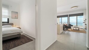 A modern hotel room with a bed, a desk, and a view of the sea. - Mamad Achziv Seaside Stylish Stay (Nahariya)